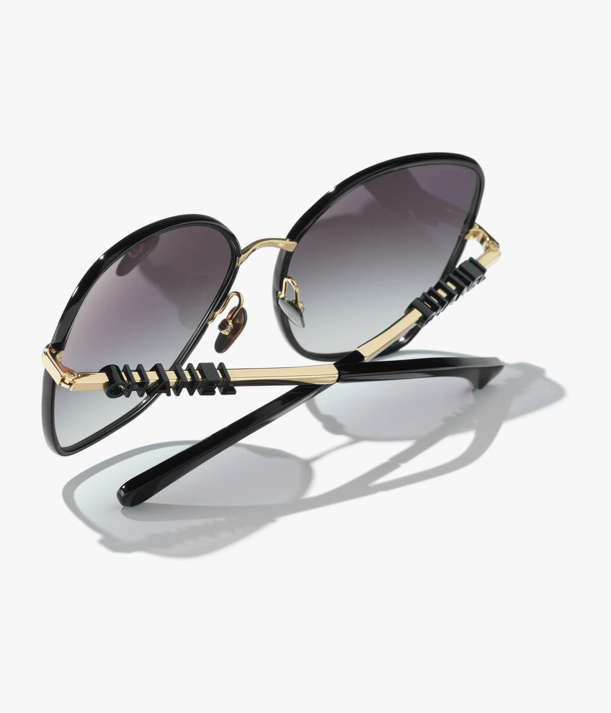 Butterfly-Sonnenbrille mit gold- und schwarzfarbenem Metallgestell und grau verlaufenden Gläsern