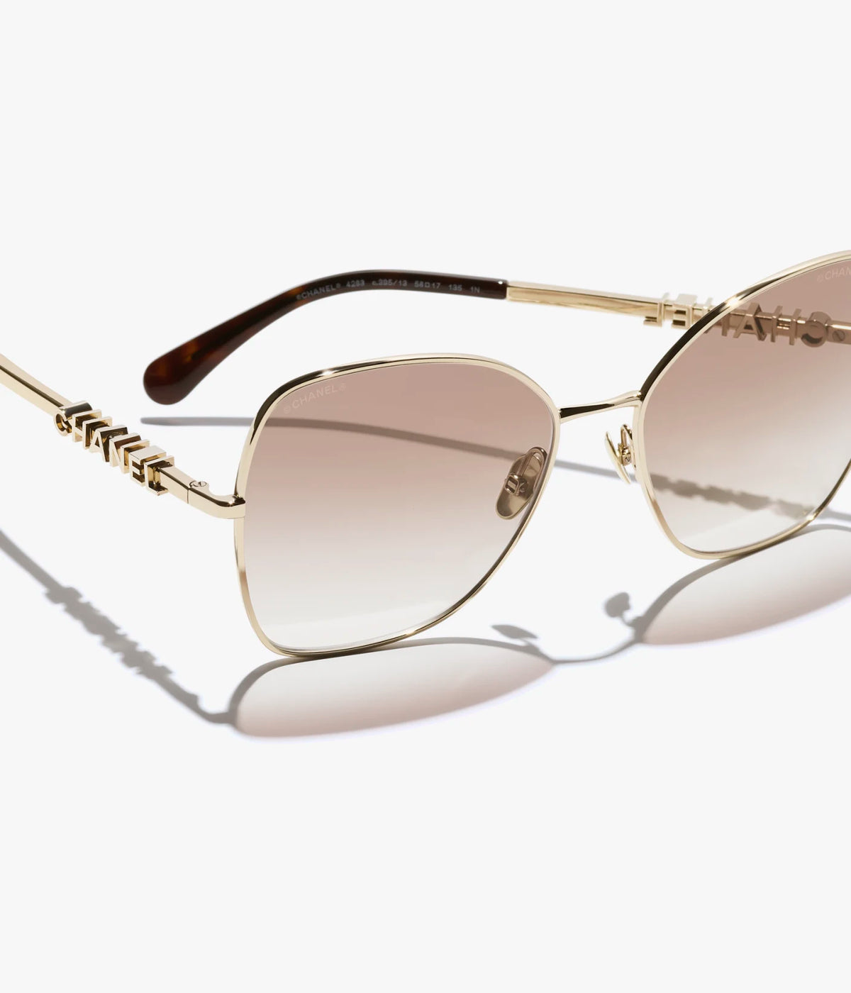 Butterfly-Sonnenbrille mit hellgoldfarbenem Metallgestell und beige verlaufenden Gläsern