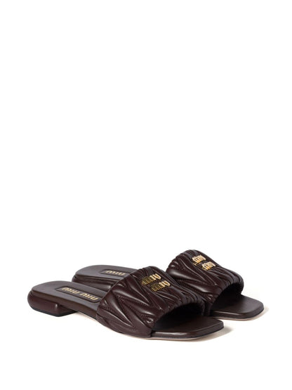 Slides made of matelassed leather in black