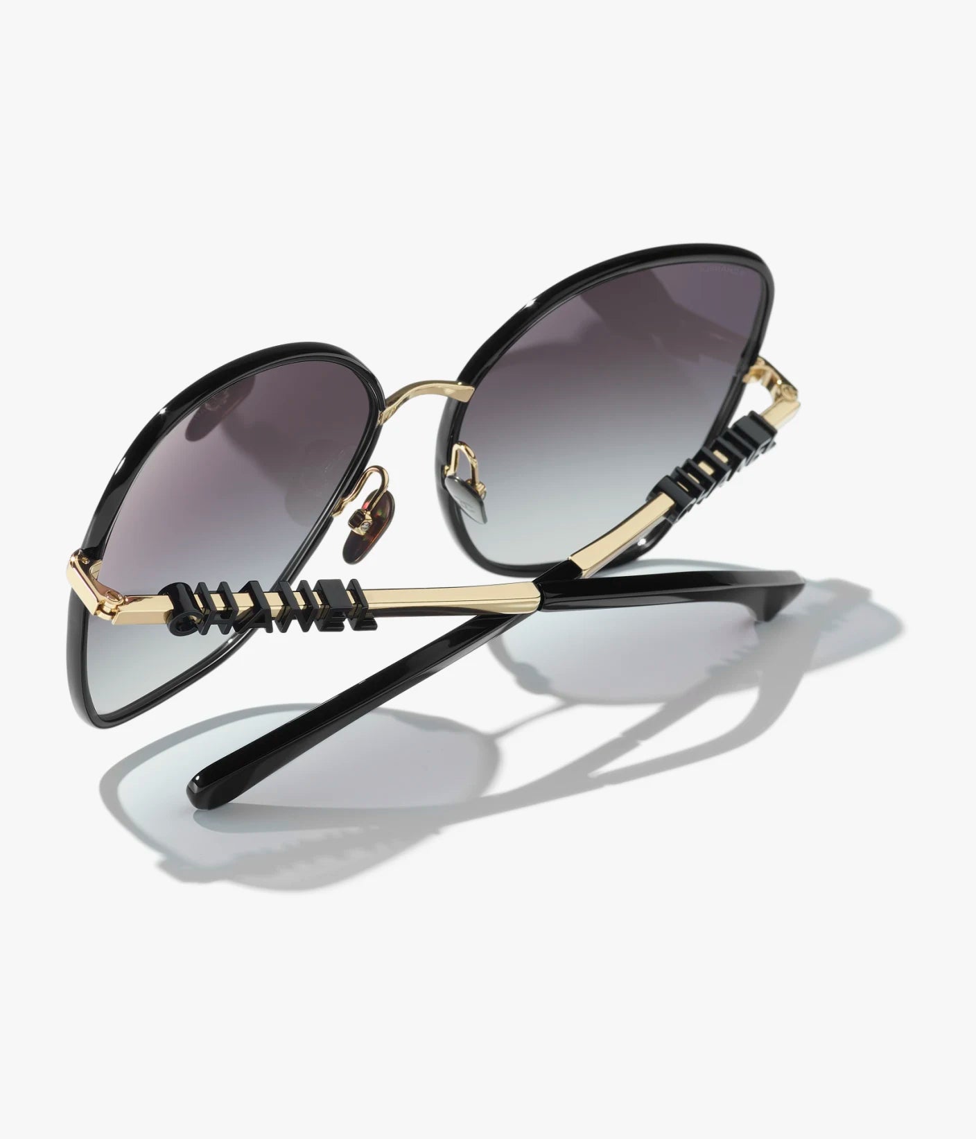 Butterfly-Sonnenbrille mit gold- und schwarzfarbenem Metallgestell und grau verlaufenden Gläsern